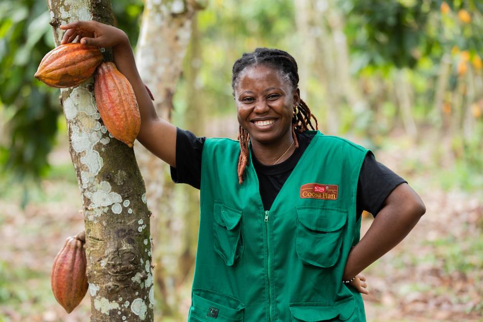 woman smiling next to cocoa tree
